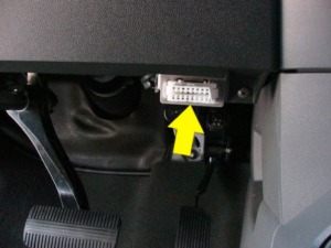 vehicle interior showing OBD2 port with a yellow arrow - chip your car performance chips
