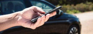 person holding smartphone near black vehicle - chip your car performance chips