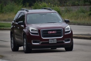 Maroon GMC Vehicle driving on road - How can GMC Performance Chips boost horsepower