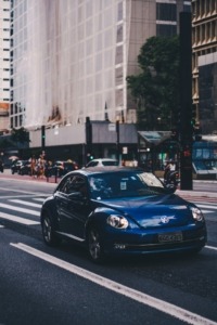 Blue Volkswagen Beetle driving in the city - Chip Your Car Volkswagen Performance Chips improve horsepower