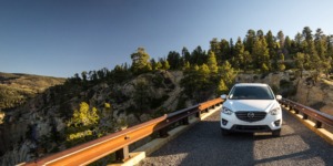 white Mazda driving through forest - chip your car performance chips