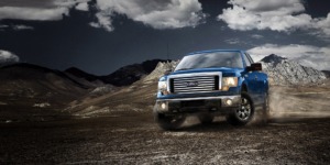 blue Ford truck driving in rocks - chip your car performance chips