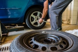 Person doing maintenance on car tires - Chip Your Car 5 Gas-Saving Tips in 2022