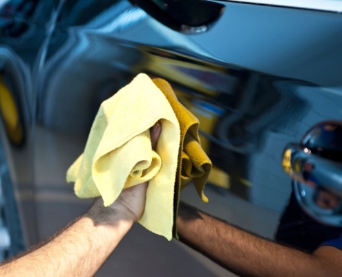 person cleaning car with a yellow cloth - chip your car ECU Chips