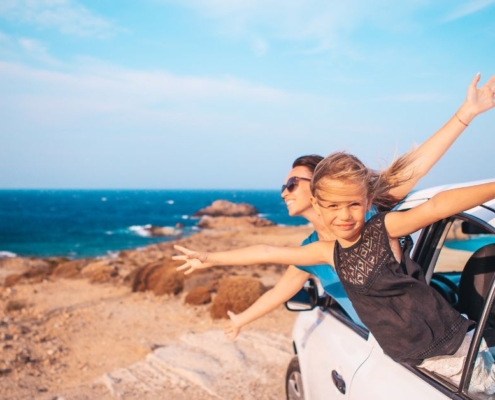 woman and child enjoying beach weather from their car - chip your car car tuner